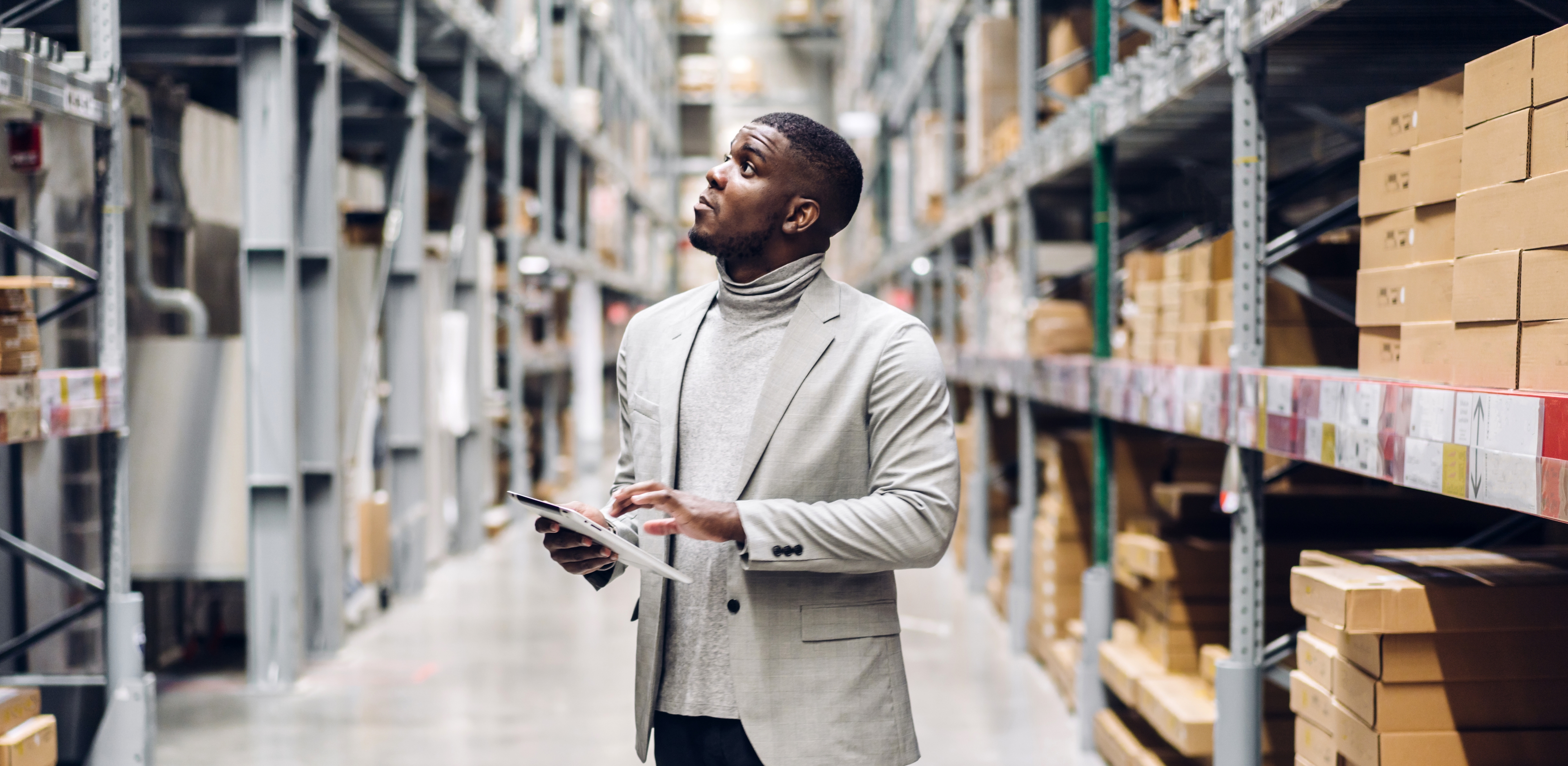 Portrait of smiling african american business man order details on tablet checking goods and supplies on shelves with goods background in warehouse.logistic and business export